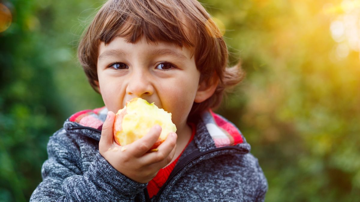 niño comiendo manzana